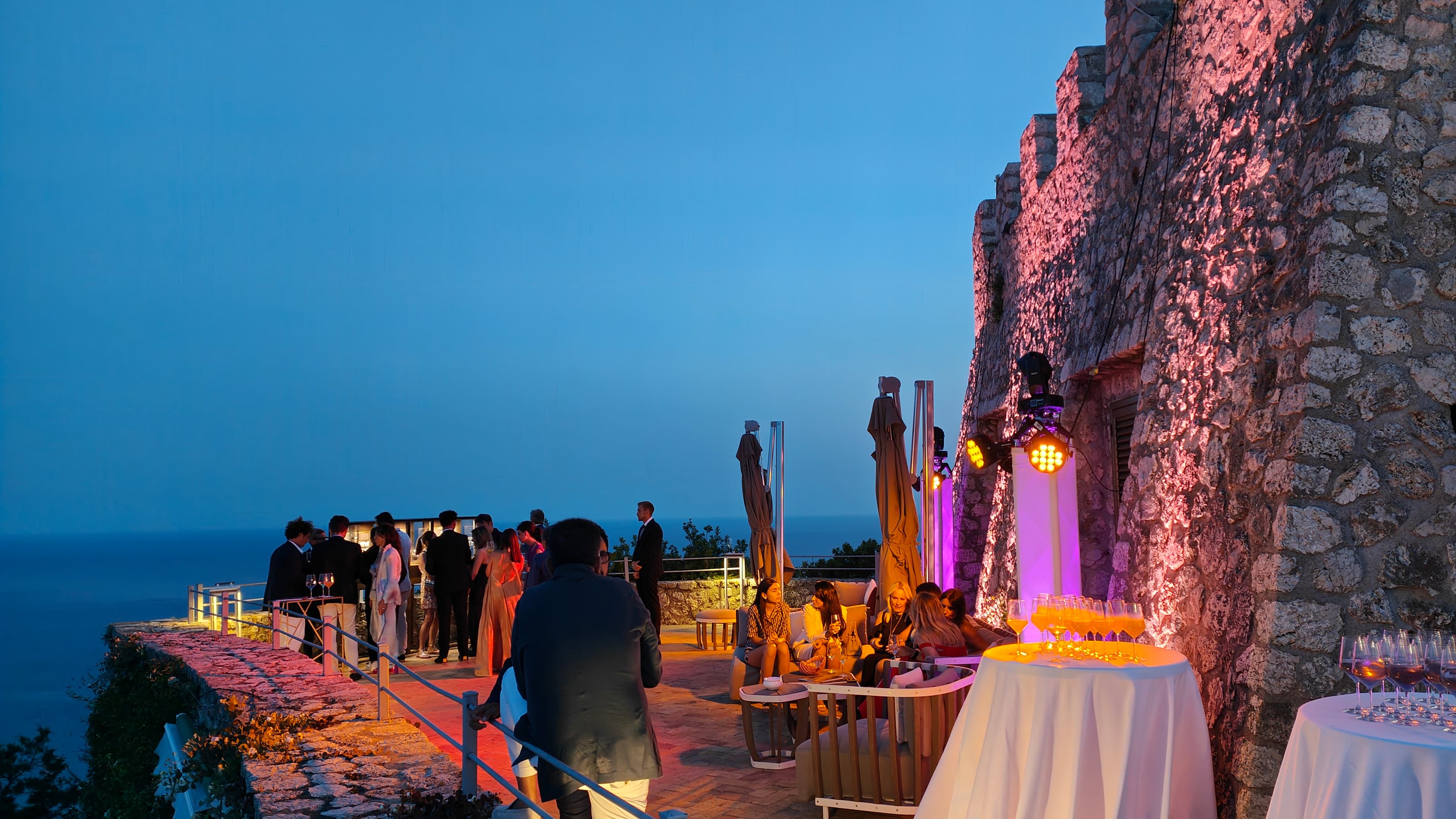 Patek Philippe private event on a stone terrace at blue hour with sea view and uplighting
